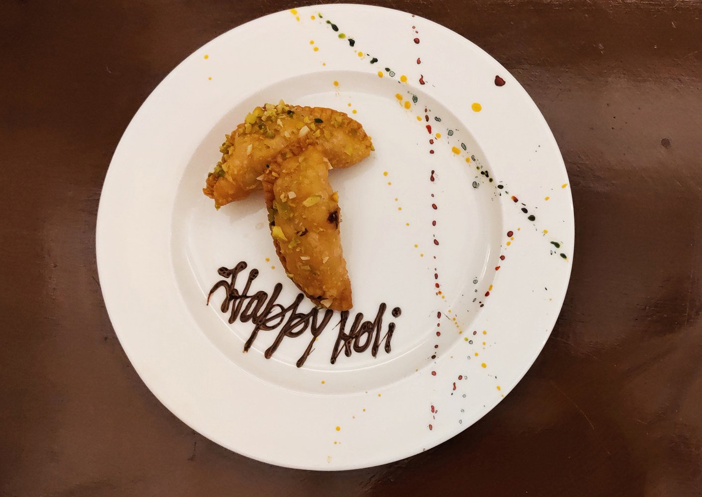 Crescent-shaped karanji with crimped edges, filled with sweet coconut